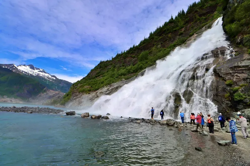 Jet boat passengers watching a humpback whale surface near Auke Bay on a Mendenhall Glacier tour with whale watching from Juneau