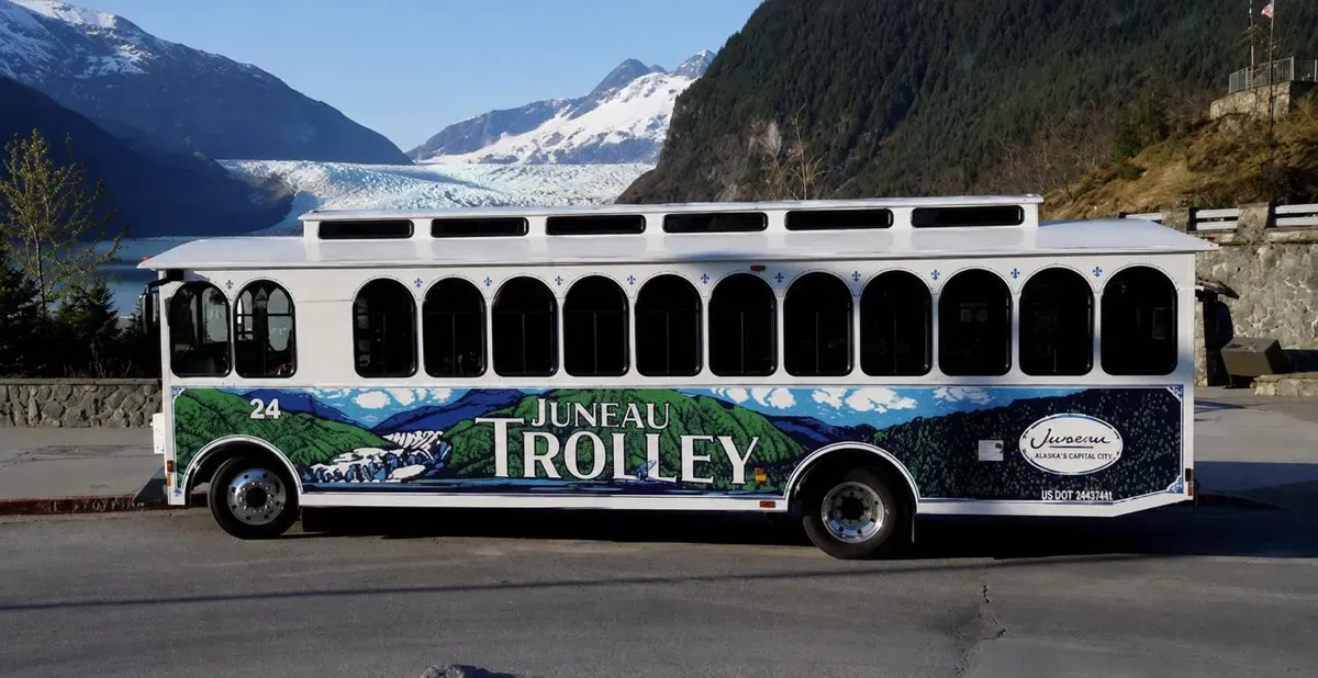 Custom trolley waiting near the visitor center parking area during a Mendenhall Glacier trolley tour from the Juneau cruise dock