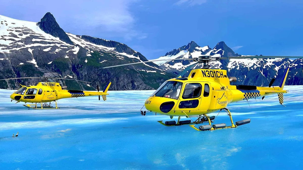 Helicopter parked on the ice with visitors walking the surface on a Juneau helicopter glacier landing tour